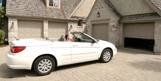 Convertible in front of a garage door